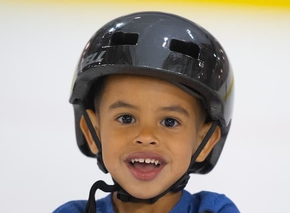 A child wearing a helmet smiles